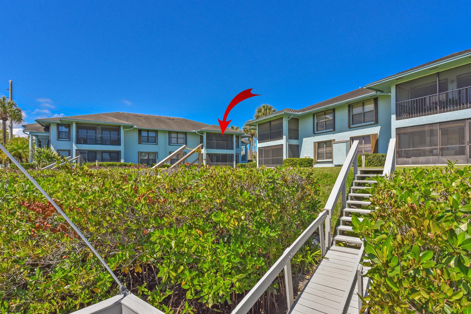 A wooden dock with railings extends over a dark river toward a dense mangrove forest — 950 S Kanner Highway # 106, Stuart FL 34994, STUART, FL