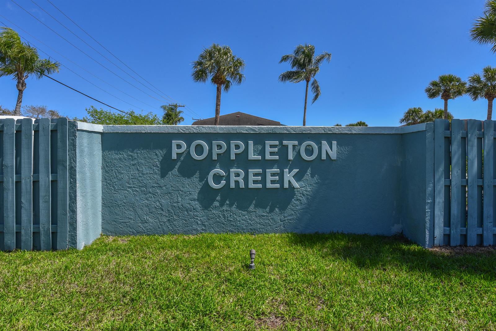 Exterior view of a multi-story apartment building with screened balconies and a wooden staircase — 950 S Kanner Highway # 106, Stuart FL 34994, STUART, FL
