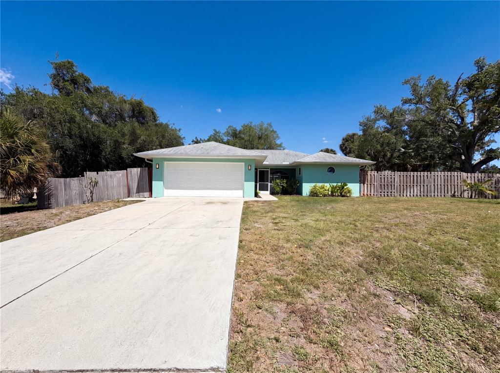 A light green single-story house with a white garage door and a concrete driveway — 212 WASHINGTON AVENUE, OSPREY, FL