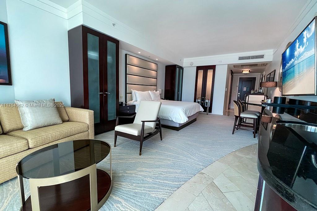 A hotel room features a bed, a seating area with a sofa, and a television — 4391 Collins ave # 616, Miami Beach FL 33140, MIAMI BEACH, FL