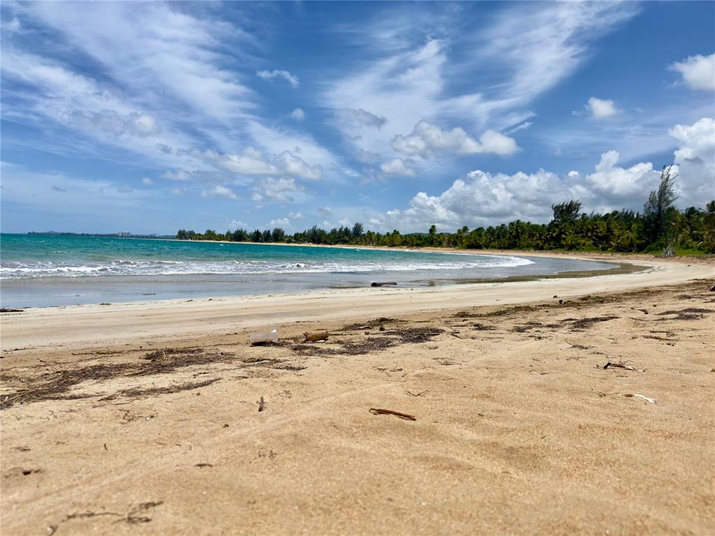 A sandy beach stretches along the coastline under a blue sky with scattered clouds — 968 CAMINO LAS PICUAS 1, RIO GRANDE, PR