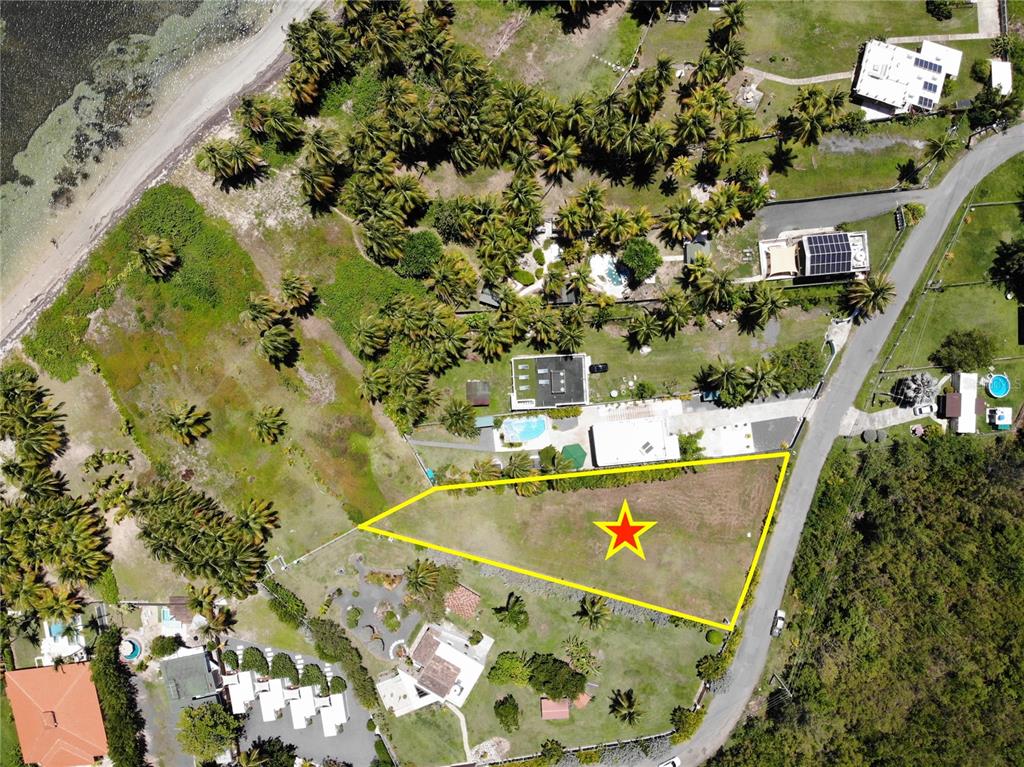 This aerial view shows a vacant, triangular-shaped lot marked with a star near a road — 968 CAMINO LAS PICUAS 1, RIO GRANDE, PR