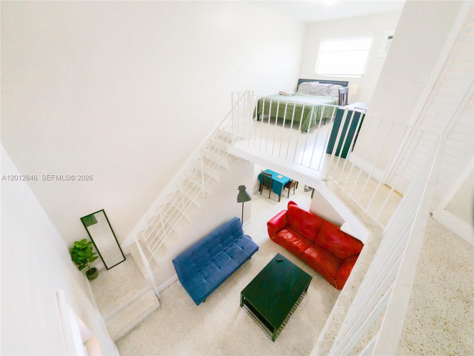 An elevated view of a two-story living area with a loft bedroom and white stairs — 1220 SW 5th St # 16, Miami FL 33135, MIAMI, FL