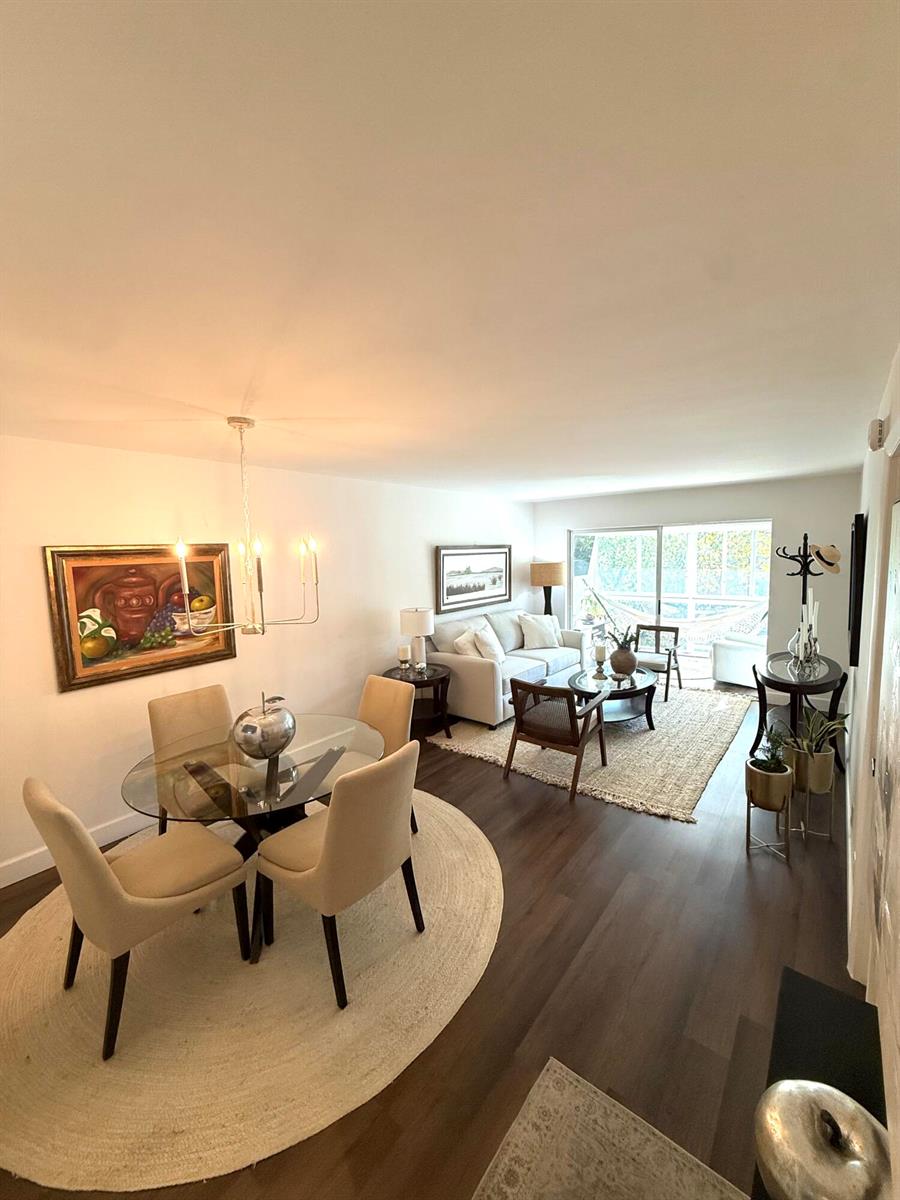 A dining area with a glass table and a living room with a sofa and rug — 3170 Holiday Springs Boulevard # 304, Margate FL 33063, MARGATE, FL