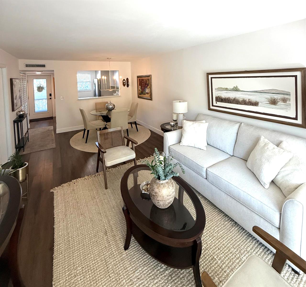 A living room and dining area feature light-colored furniture, wood flooring, and neutral rugs — 3170 Holiday Springs Boulevard # 304, Margate FL 33063, MARGATE, FL