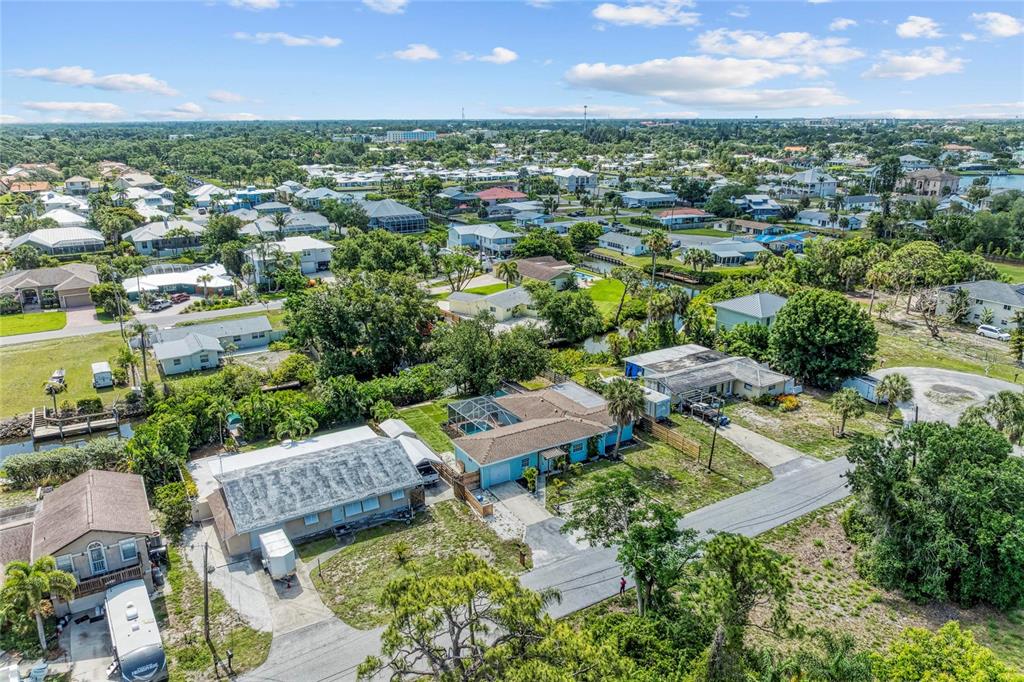 An aerial view shows several residential houses with pools and driveways in a suburban neighborhood — 312 WINFIELD WAY, NOKOMIS, FL