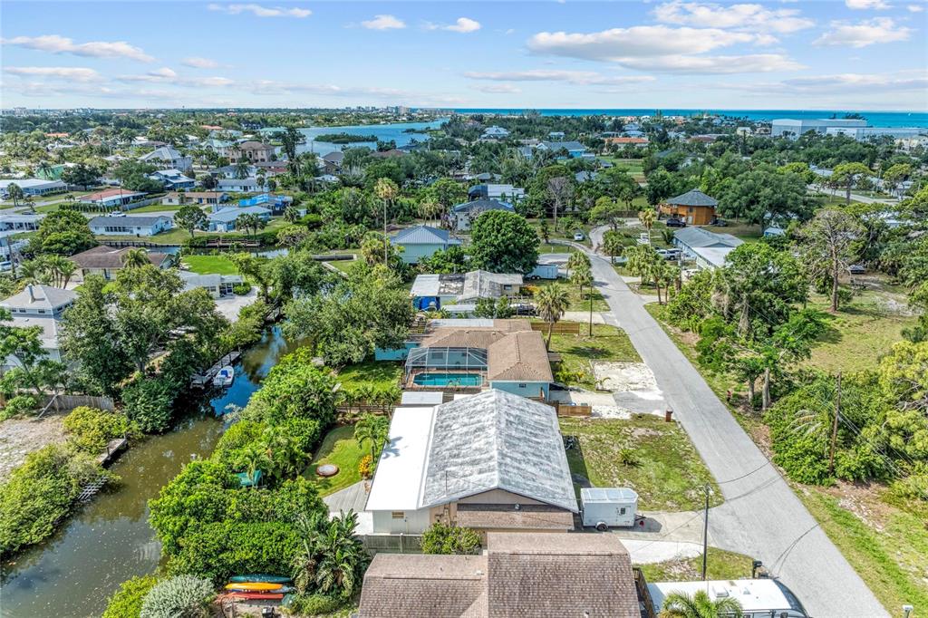 An aerial view shows a house with a pool, a canal, and a nearby road — 312 WINFIELD WAY, NOKOMIS, FL