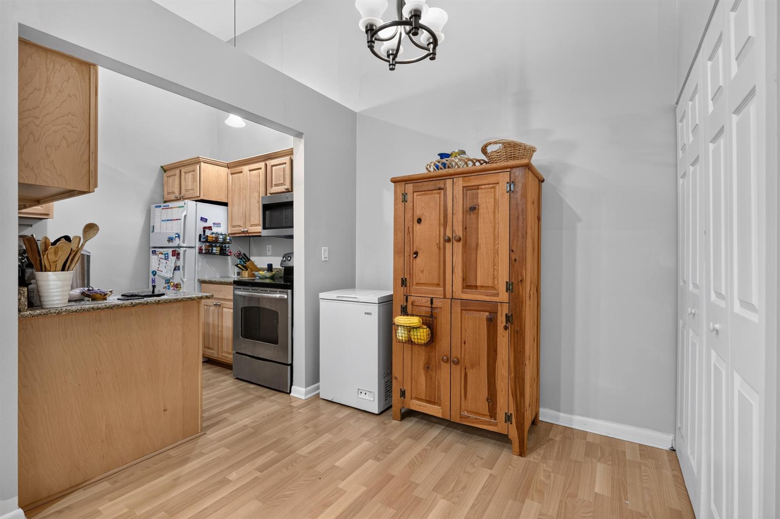 A kitchen with light wood cabinets, stainless steel appliances, and a wooden storage cabinet — 6258 Chasewood Drive # G, Jupiter FL 33458, JUPITER, FL