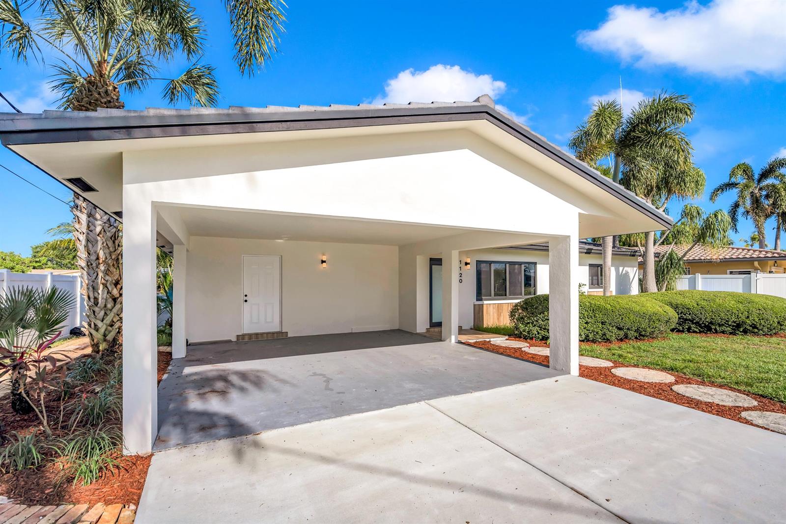 A white house exterior features a large covered carport and a concrete driveway — 1120 SE 9th Avenue, Pompano Beach FL 33060, POMPANO BEACH, FL