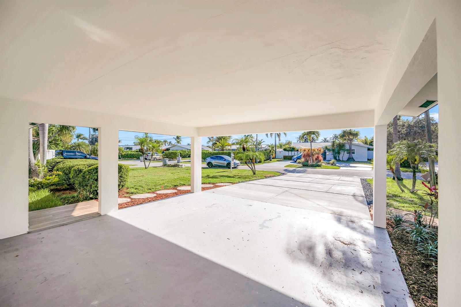 A covered concrete carport with white pillars overlooks a residential street and a grassy yard — 1120 SE 9th Avenue, Pompano Beach FL 33060, POMPANO BEACH, FL