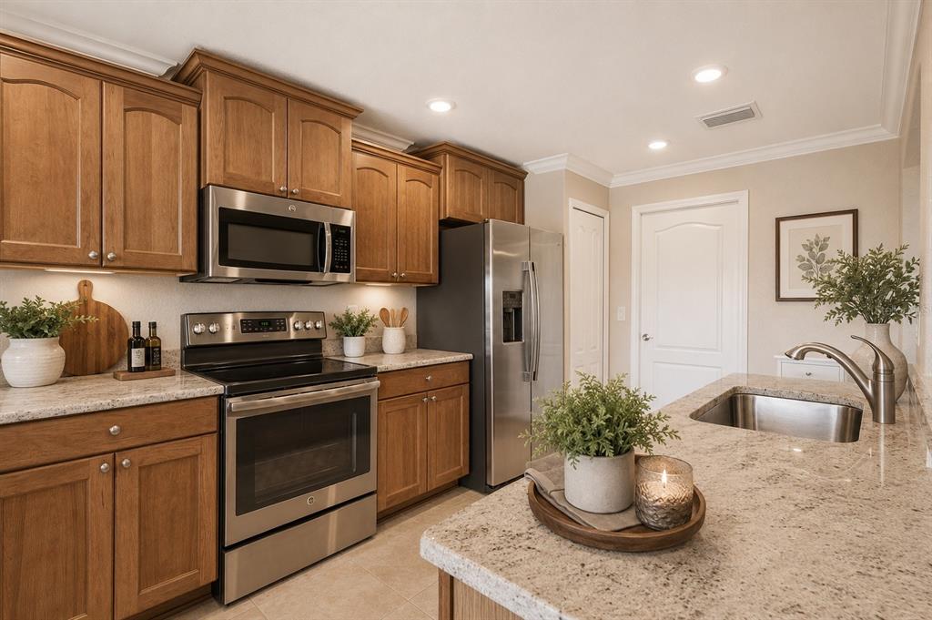 A kitchen features wood cabinets, stainless steel appliances, and granite countertops with an island sink — 27143 ROANOKE DRIVE, LEESBURG, FL