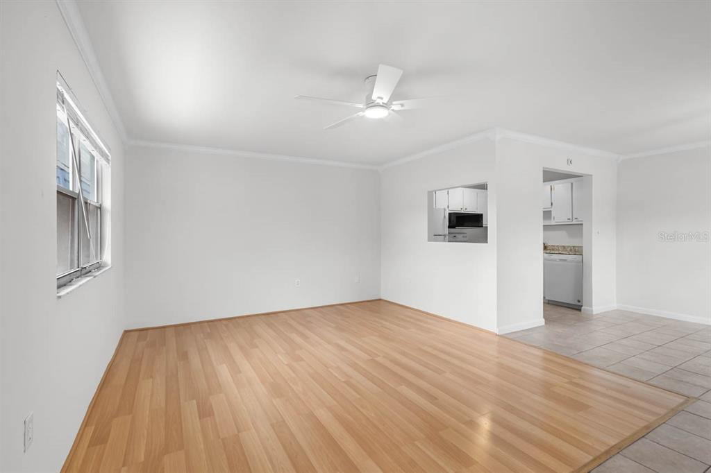 An empty living room with light wood flooring, white walls, and a ceiling fan — 1901 ANDOVER WAY UNIT 38, SUN CITY CENTER, FL