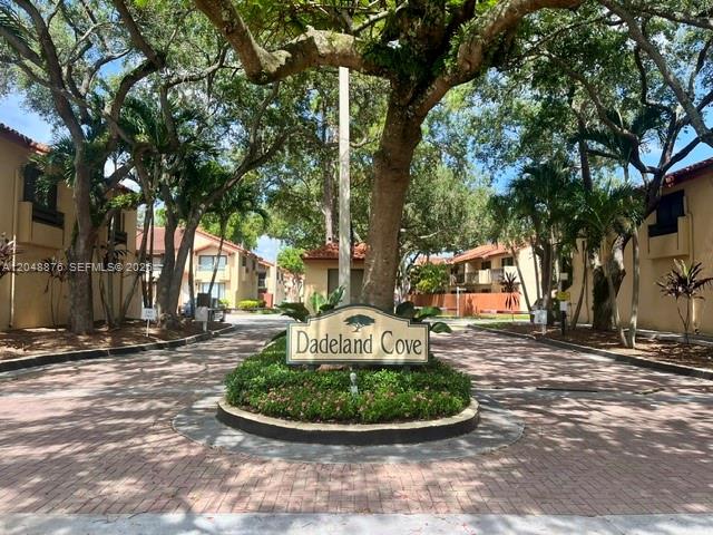 The entrance to Dadeland Cove features a brick driveway and a prominent community sign — 10211 SW 77th Ct, Miami FL 33156, MIAMI, FL