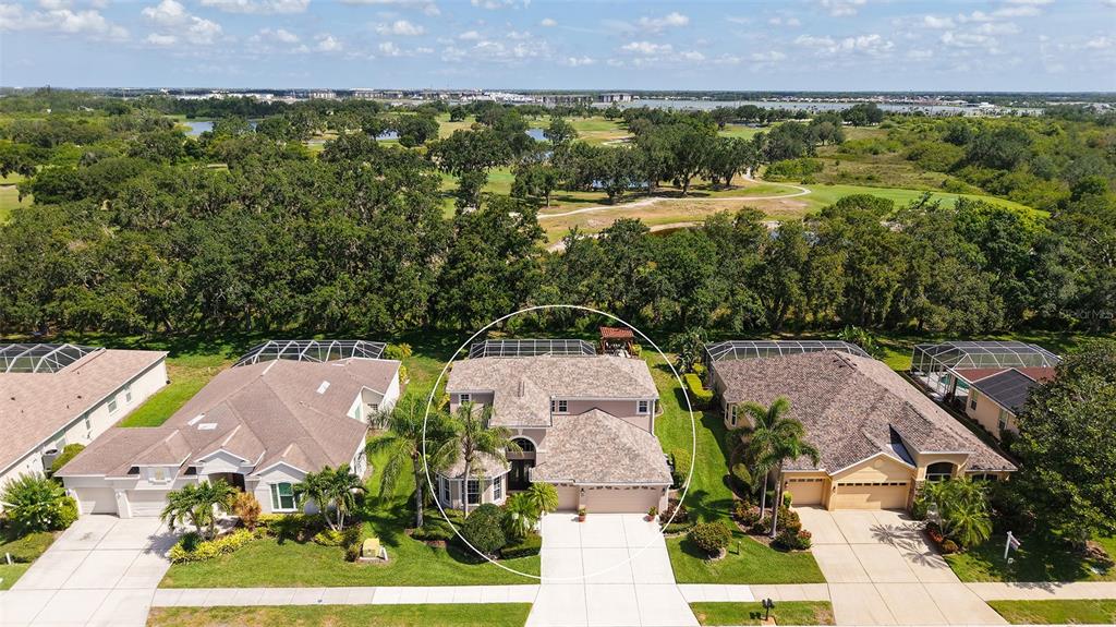 An aerial view shows a suburban house with a screened pool enclosure and golf course — 7915 KAVANAGH COURT, SARASOTA, FL