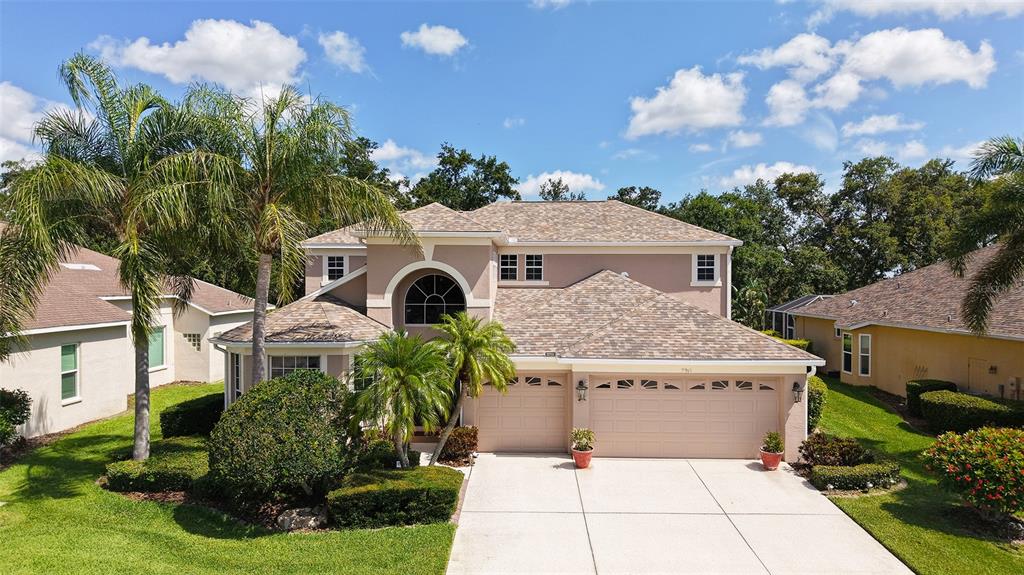 An aerial view shows a two-story suburban house with a three-car garage and palm trees — 7915 KAVANAGH COURT, SARASOTA, FL