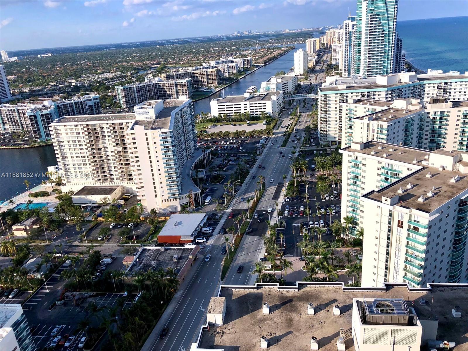 An aerial view shows high-rise apartment buildings, a multi-lane road, and a canal in Florida — 4111 S Ocean Dr # 2910, Hollywood FL 33019, HOLLYWOOD, FL