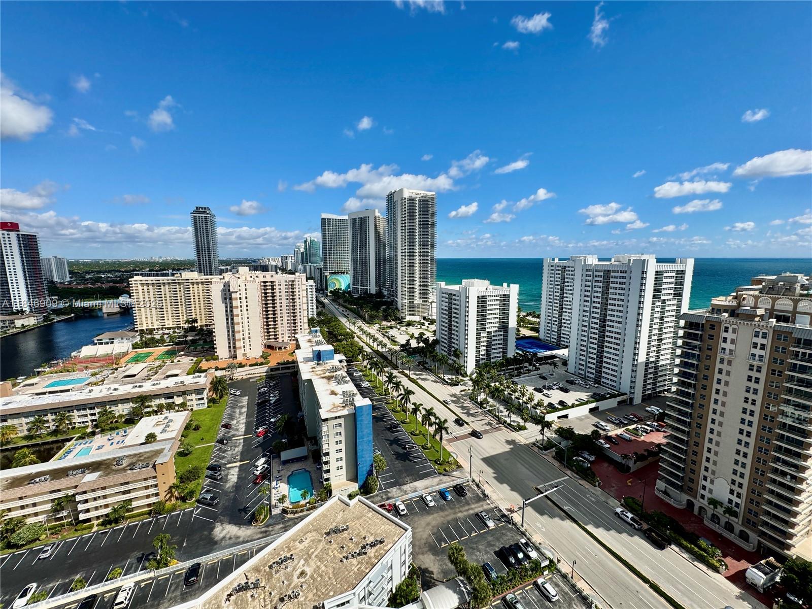 An aerial view shows high-rise buildings, a coastal road, and parking lots near the ocean — 1945 S Ocean Dr # 2311, Hallandale Beach FL 33009, HALLANDALE BEACH, FL