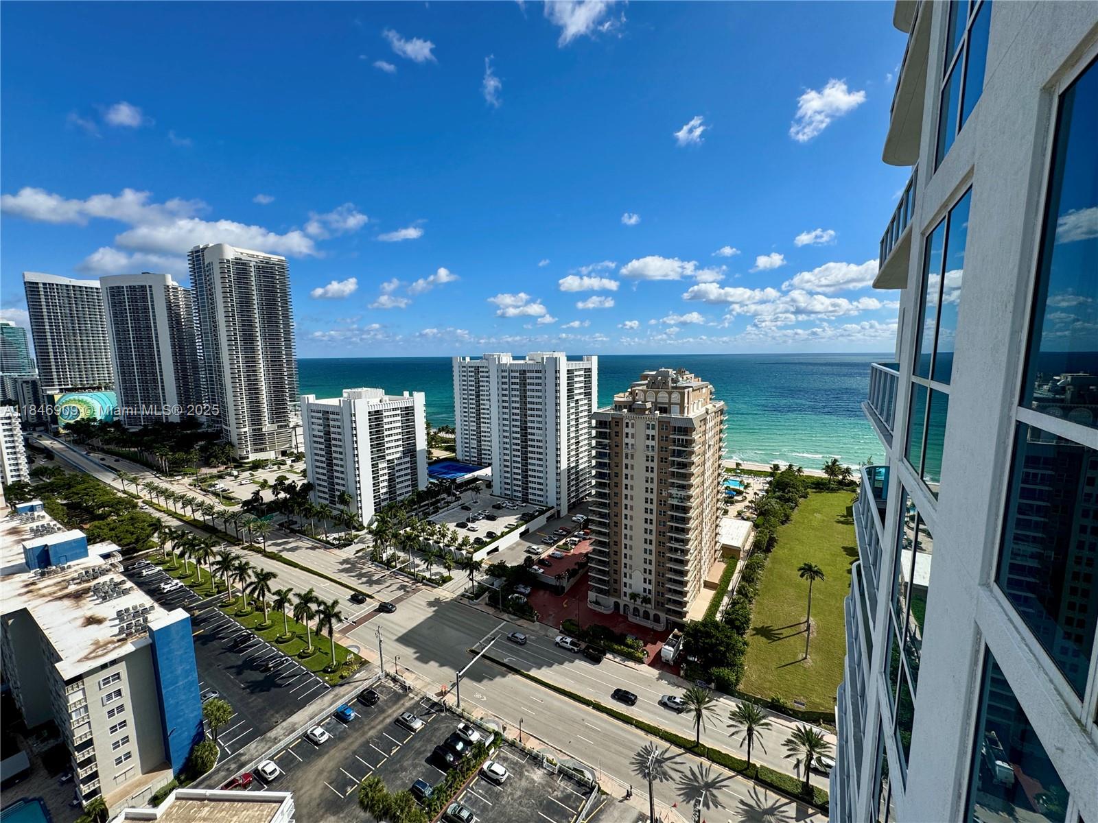 A high-angle view shows multiple residential high-rise buildings near the ocean and a parking lot — 1945 S Ocean Dr # 2311, Hallandale Beach FL 33009, HALLANDALE BEACH, FL