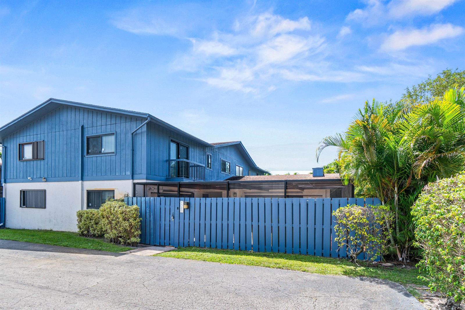 A two-story blue house with a fenced-in patio area and a paved driveway — 4585 Holly Lake Drive, Lake Worth FL 33463, LAKE WORTH, FL