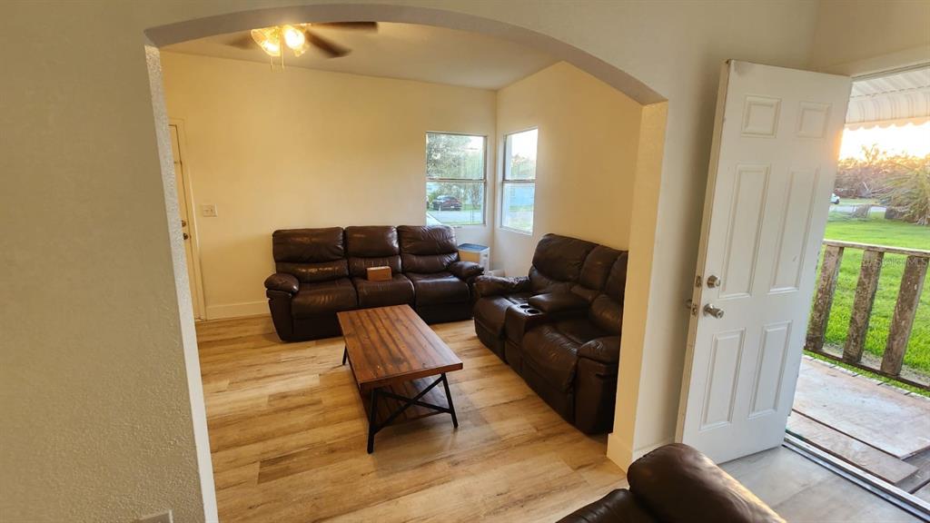 A living room features brown leather sofas, a wood coffee table, and light wood-look flooring — 412 BAY STREET NW, FORT MEADE, FL