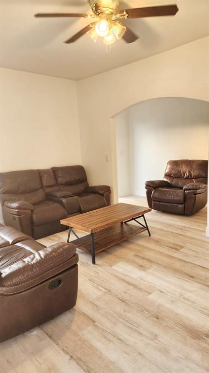 A living room features brown leather reclining furniture, a wooden coffee table, and light flooring — 412 BAY STREET NW, FORT MEADE, FL