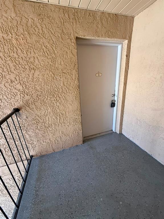 A beige stucco exterior wall features a white door with a lockbox on a balcony — 2400 BARLEY CLUB COURT UNIT 3, ORLANDO, FL