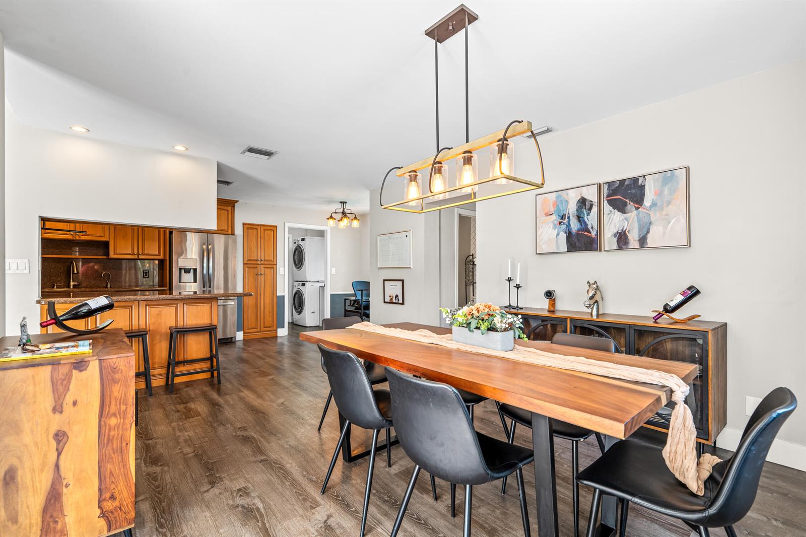A dining room with a wooden table, black chairs, and an adjacent kitchen — 1912 NW 77th Avenue, Margate FL 33063, MARGATE, FL