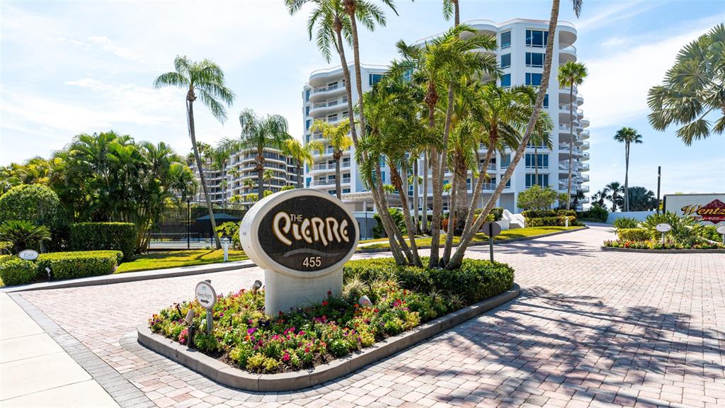 An exterior view of a multi-story residential building with a prominent sign and palm trees — 455 LONGBOAT CLUB ROAD UNIT PH1, LONGBOAT KEY, FL
