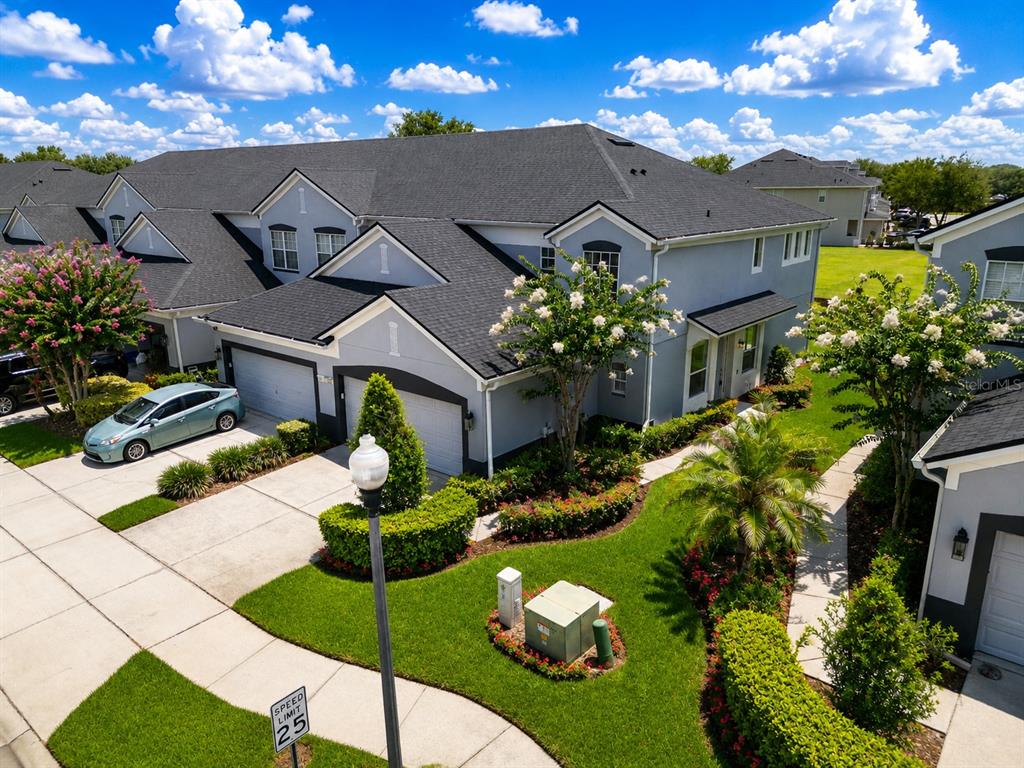 An aerial view of a two-story gray townhouse with a dark shingled roof and landscaping — 1323 SHALLCROSS AVENUE, ORLANDO, FL