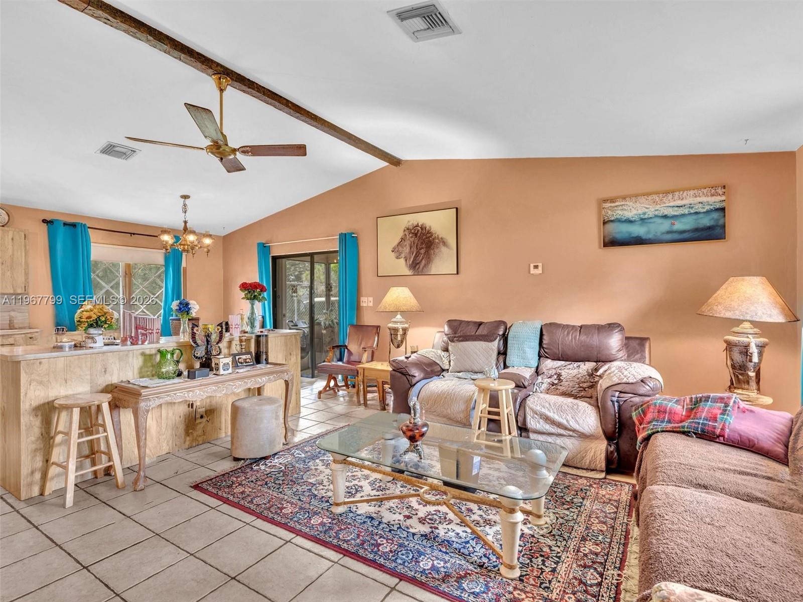 A living room with tile floors, a vaulted ceiling, and a brown leather sofa — 5310 SW 109th Ave, Davie FL 33328, DAVIE, FL