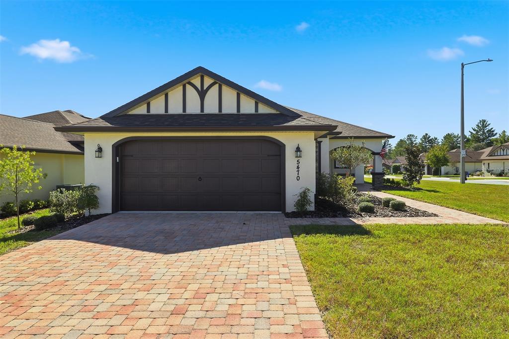 A single-story house with a two-car garage, a brick paver driveway, and a gabled roof — 5470 W HUNTER RUN LANE, HOMOSASSA, FL