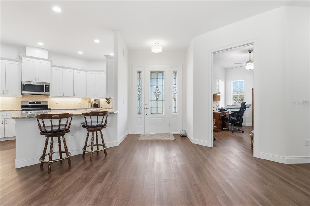 A kitchen with white cabinets and a breakfast bar opens into an entryway and office — 5470 W HUNTER RUN LANE, HOMOSASSA, FL