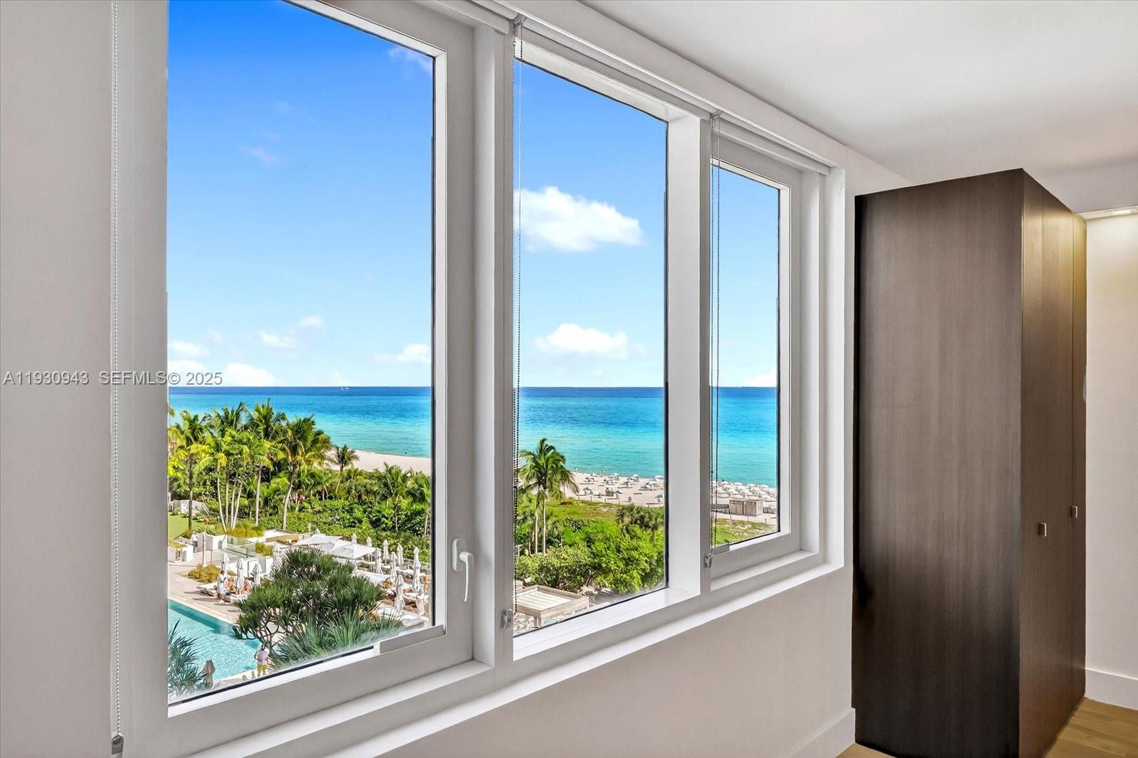 A room with white walls and a large window overlooking the ocean and pool — 2301 Collins Ave # 714, Miami Beach FL 33139, MIAMI BEACH, FL