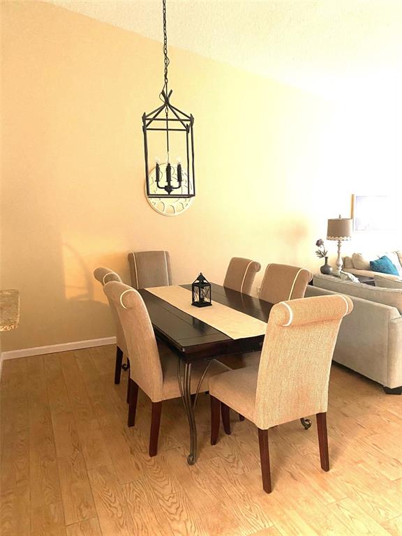 A dining area features a dark wood table, six upholstered chairs, and a hanging lantern fixture — 3645 WHITE PINE COURT UNIT 128, SARASOTA, FL