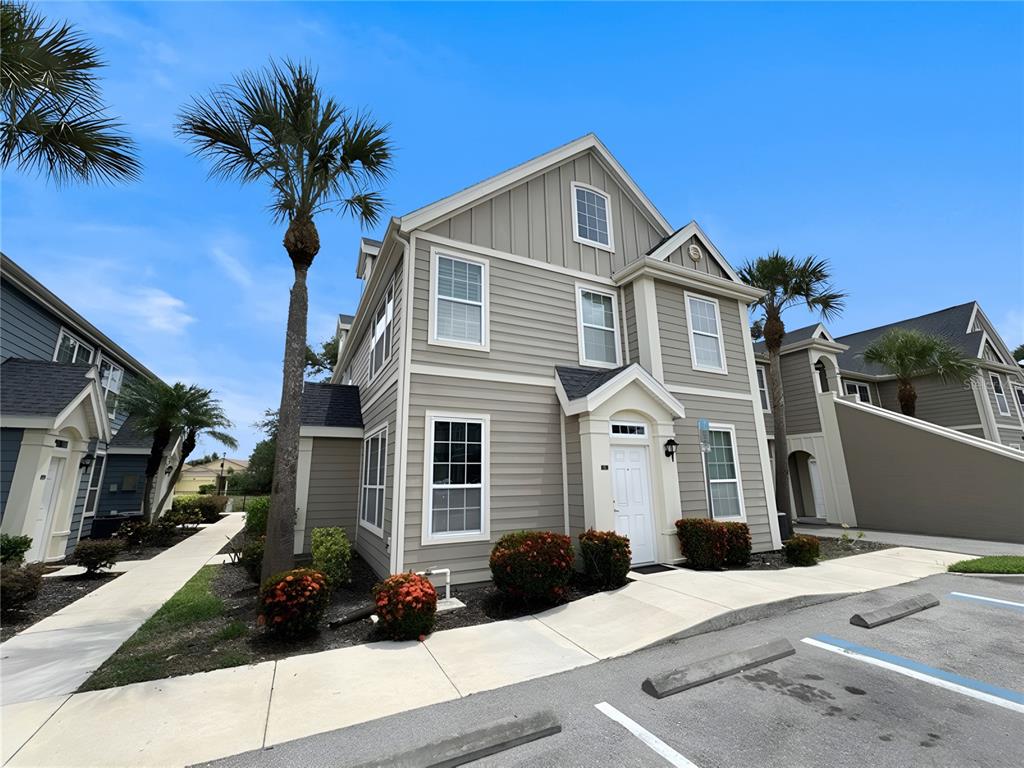 A light gray, two-story residential building with a white front door and palm trees — 5531 ROSEHILL ROAD UNIT 201, SARASOTA, FL