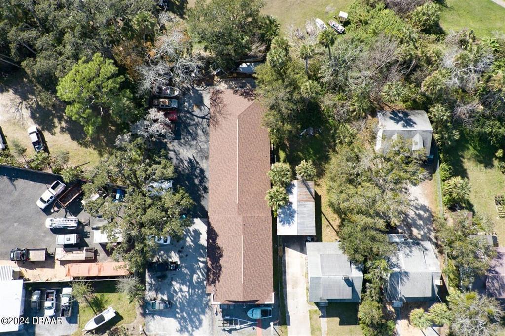 An aerial view shows a long building with a brown roof surrounded by trees — 5110 S RIDGEWOOD AVENUE, PORT ORANGE, FL