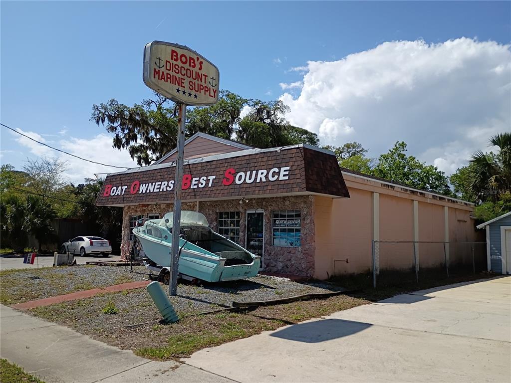 A light-colored building with a boat parked in front and a large sign overhead — 5110 S RIDGEWOOD AVENUE, PORT ORANGE, FL