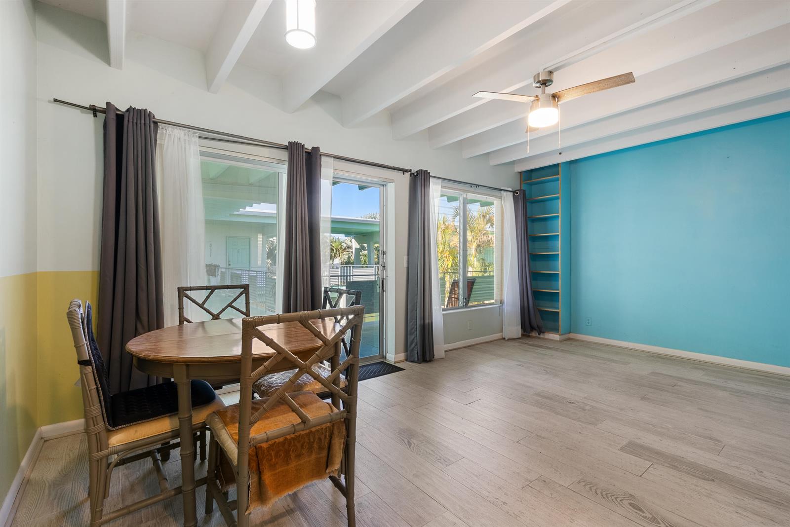 A dining area with a wooden table, chairs, and a blue accent wall with shelving — 702 N Federal Highway # B4, FL 33460, FL