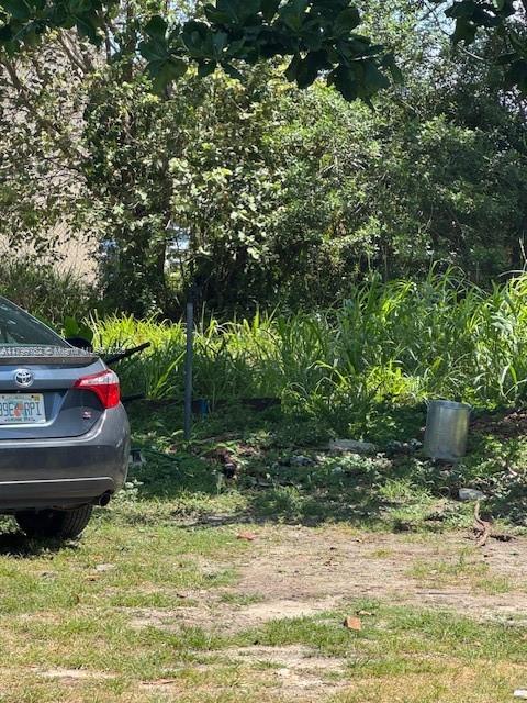 A gray sedan is parked on a dirt lot next to a metal trash can — 10250 SW 177 st, Miami FL 33157, MIAMI, FL