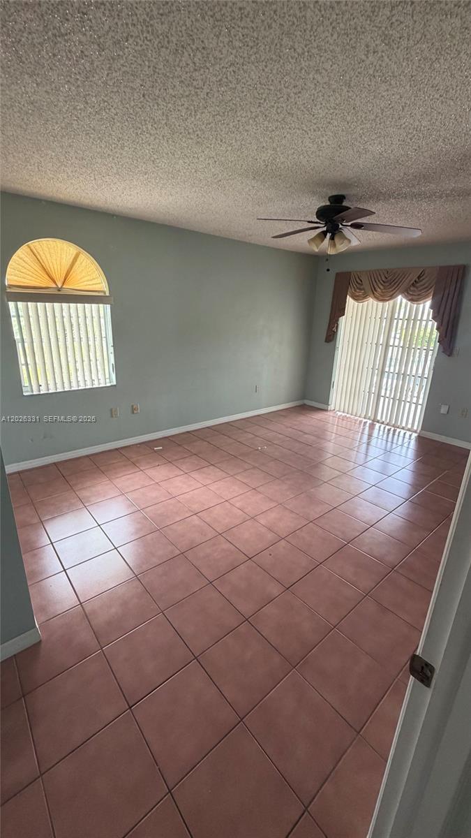 An empty room features light-colored walls, a ceiling fan, and large, square floor tiles — 770 E 19th St # A, Hialeah FL 33013, HIALEAH, FL