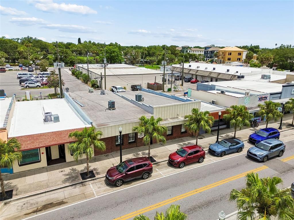 An aerial view shows a row of commercial buildings with parked cars along the street — 5701 MAIN STREET, NEW PORT RICHEY, FL
