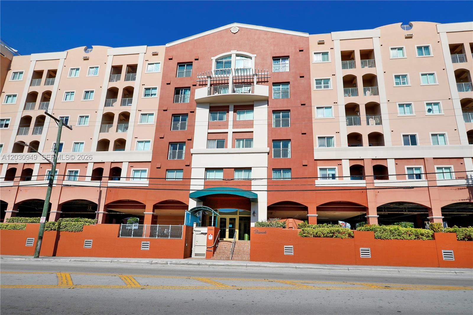 The exterior of a multi-story apartment building features a red and beige facade — 2280 SW 32nd Ave # 605, Miami FL 33145, MIAMI, FL