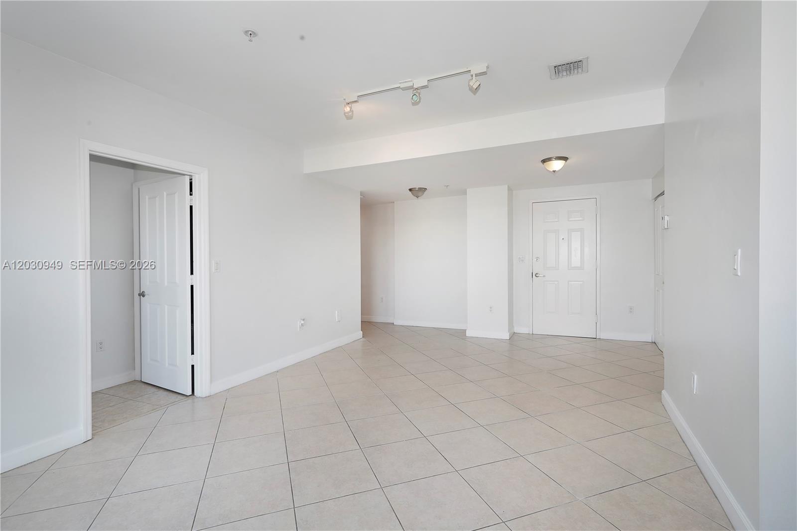 An empty room with white walls, tiled floors, a track light, and two white doors — 2280 SW 32nd Ave # 605, Miami FL 33145, MIAMI, FL