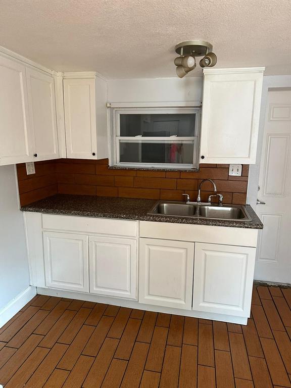 A kitchen features white cabinets, a dark speckled countertop, a double sink, and brown tile — 3718 19TH AVENUE S, ST PETERSBURG, FL