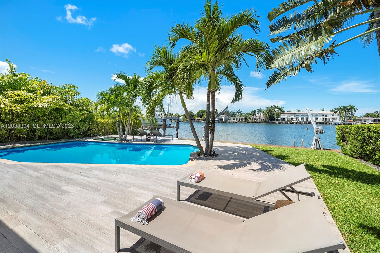 A swimming pool sits on a patio with lounge chairs overlooking a waterfront canal — 365 N Shore Dr, Miami Beach FL 33141, MIAMI BEACH, FL