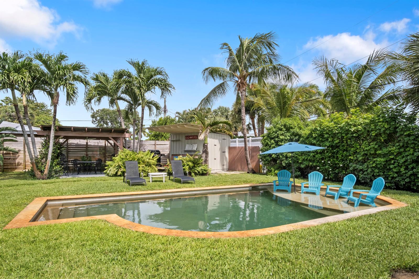 A backyard features a swimming pool with lounge chairs, a pergola, and palm trees — 15 N Swinton Circle, Delray Beach FL 33444, DELRAY BEACH, FL