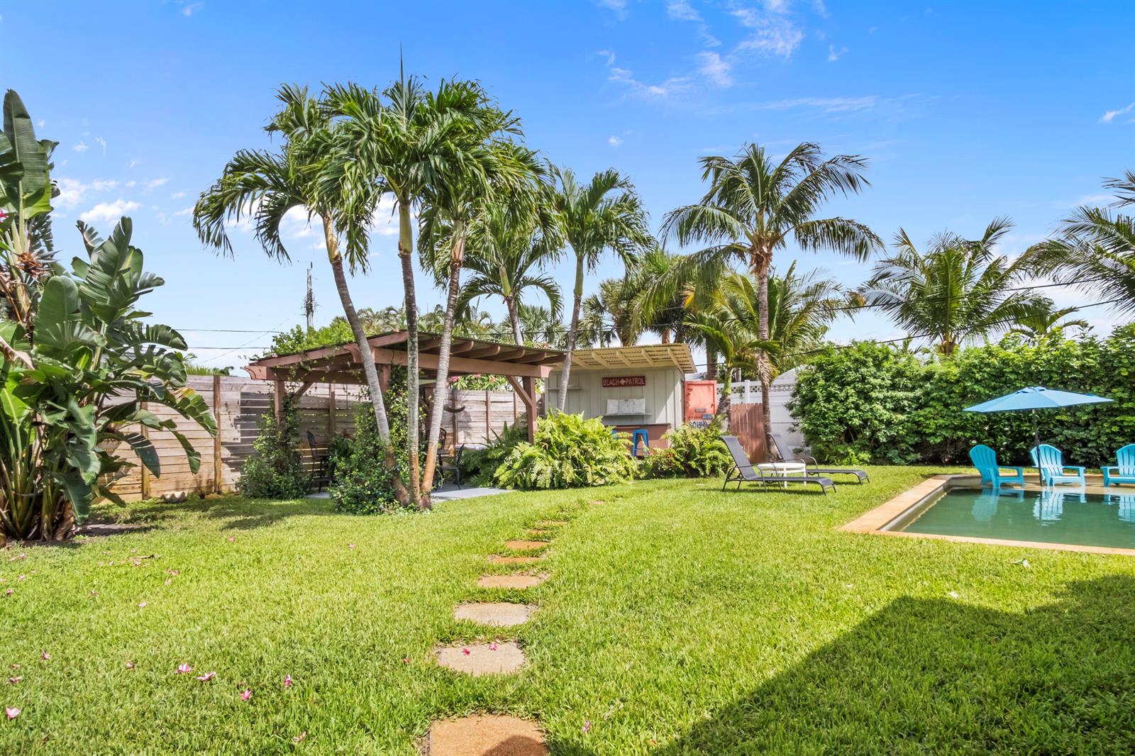 A backyard features a swimming pool, a wooden pergola, palm trees, and a small shed — 15 N Swinton Circle, Delray Beach FL 33444, DELRAY BEACH, FL