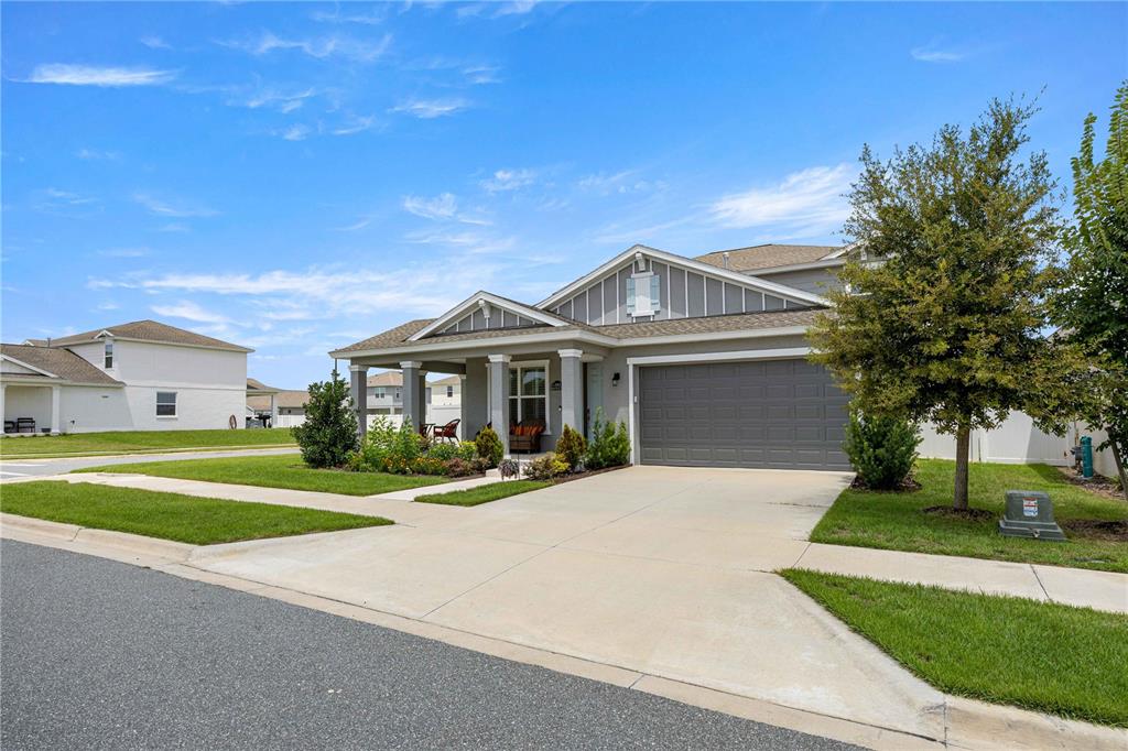 A single-story suburban house with a gray garage, covered porch, and a concrete driveway — 7539 SW 64TH STREET ROAD, OCALA, FL