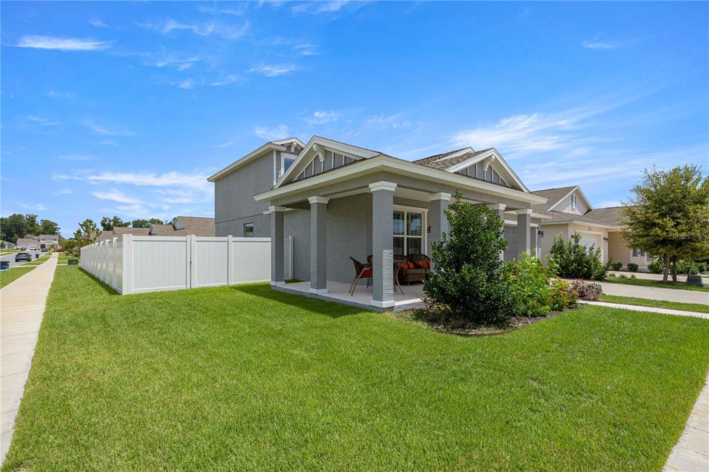 A gray house with a covered front porch and a white vinyl privacy fence — 7539 SW 64TH STREET ROAD, OCALA, FL