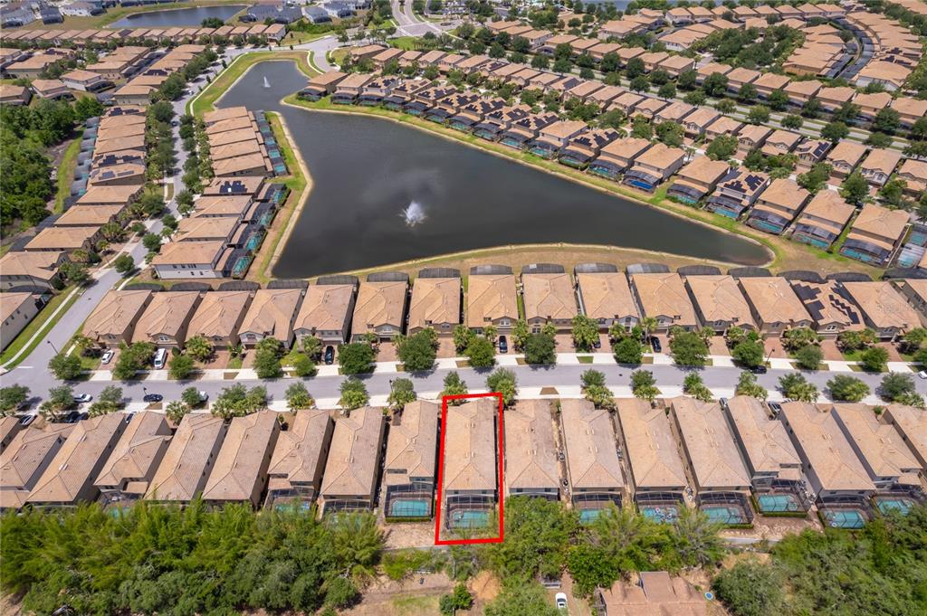 An aerial view shows a residential neighborhood with a central pond and a highlighted house — 1881 NICE COURT, KISSIMMEE, FL
